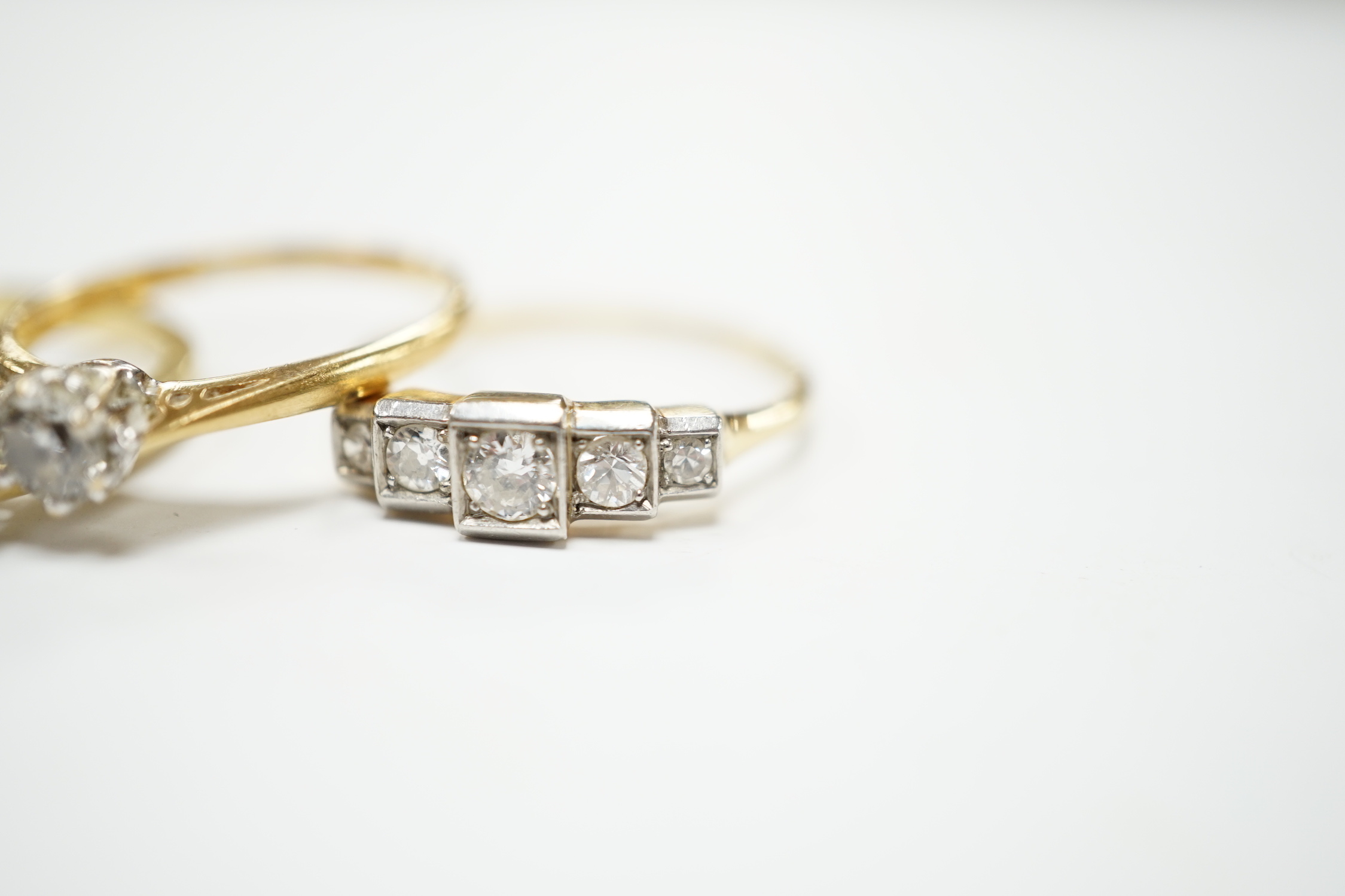 Four assorted 18ct and diamond set rings including a graduated five stone, three stone and two solitaires, gross weight 10.3 grams.